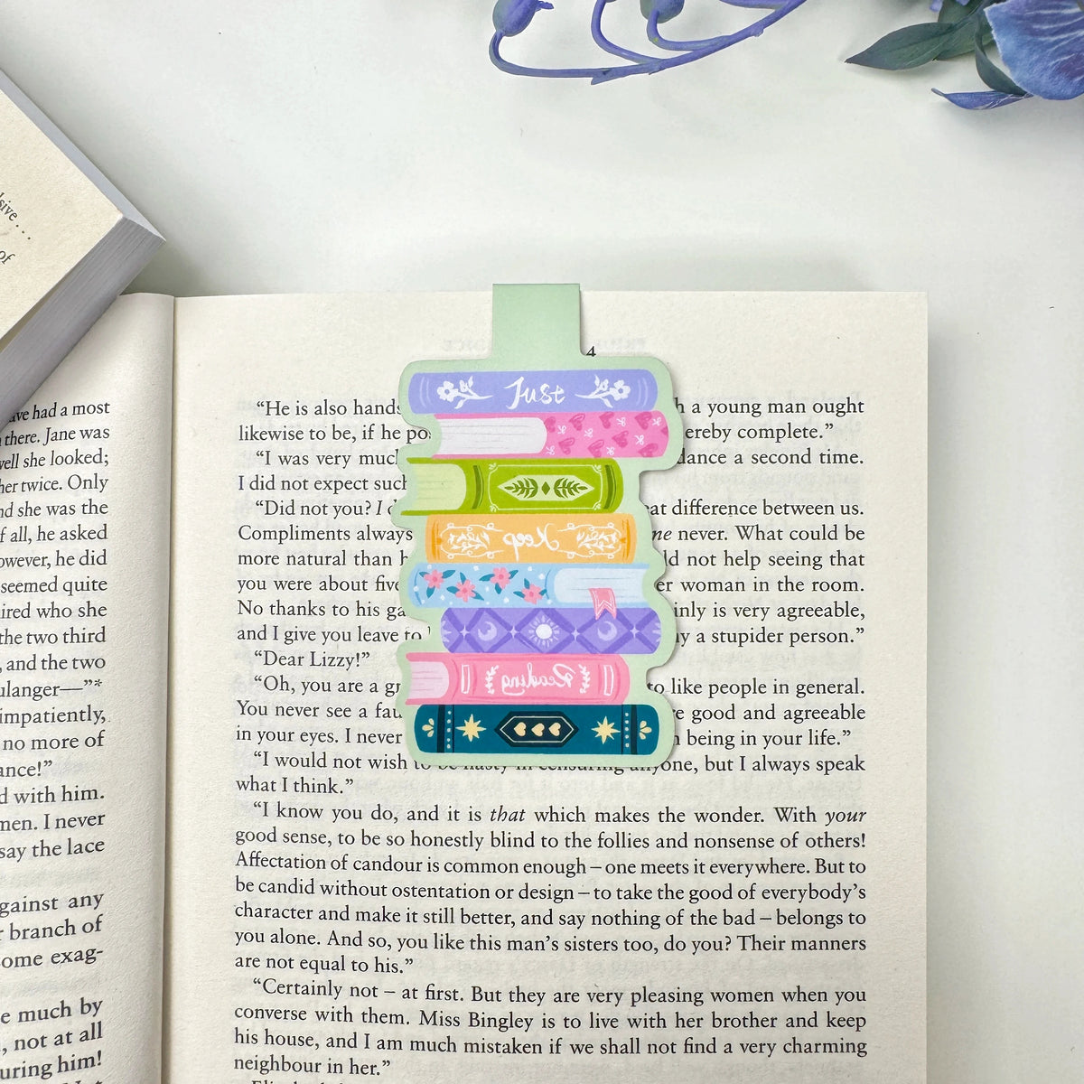 Just Keep Reading book stack magnetic bookmark clipped over a page of an open book