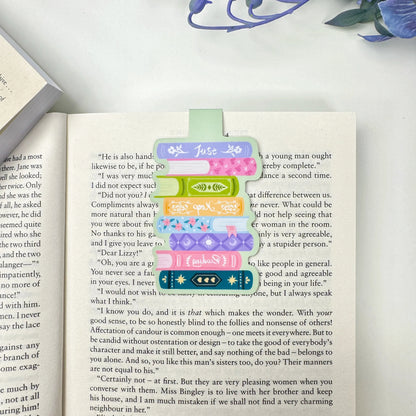 Just Keep Reading book stack magnetic bookmark clipped over a page of an open book