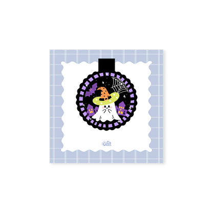 Witch Hat Ghost holographic magnetic bookmark with a white ghost, orange witch hat, spiderweb, bat and purple houses