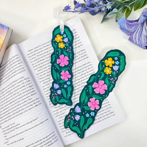 Garden in Bloom floral acrylic bookmark with lace beside matching floral artwork on an open book