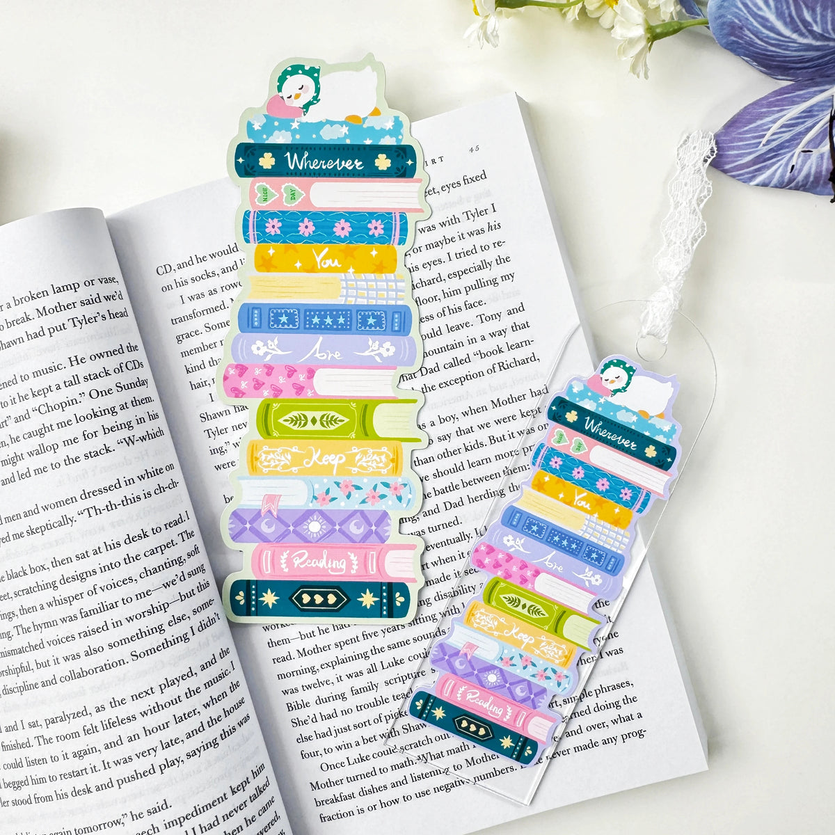 Book stack classic bookmark beside a matching acrylic lace bookmark, sold separately, on an open book