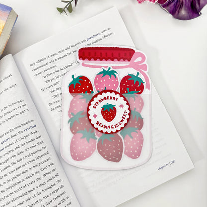 Strawberry Jar Bookmark Set displayed on an open book with three removable bookmarks tucked into the jar holder