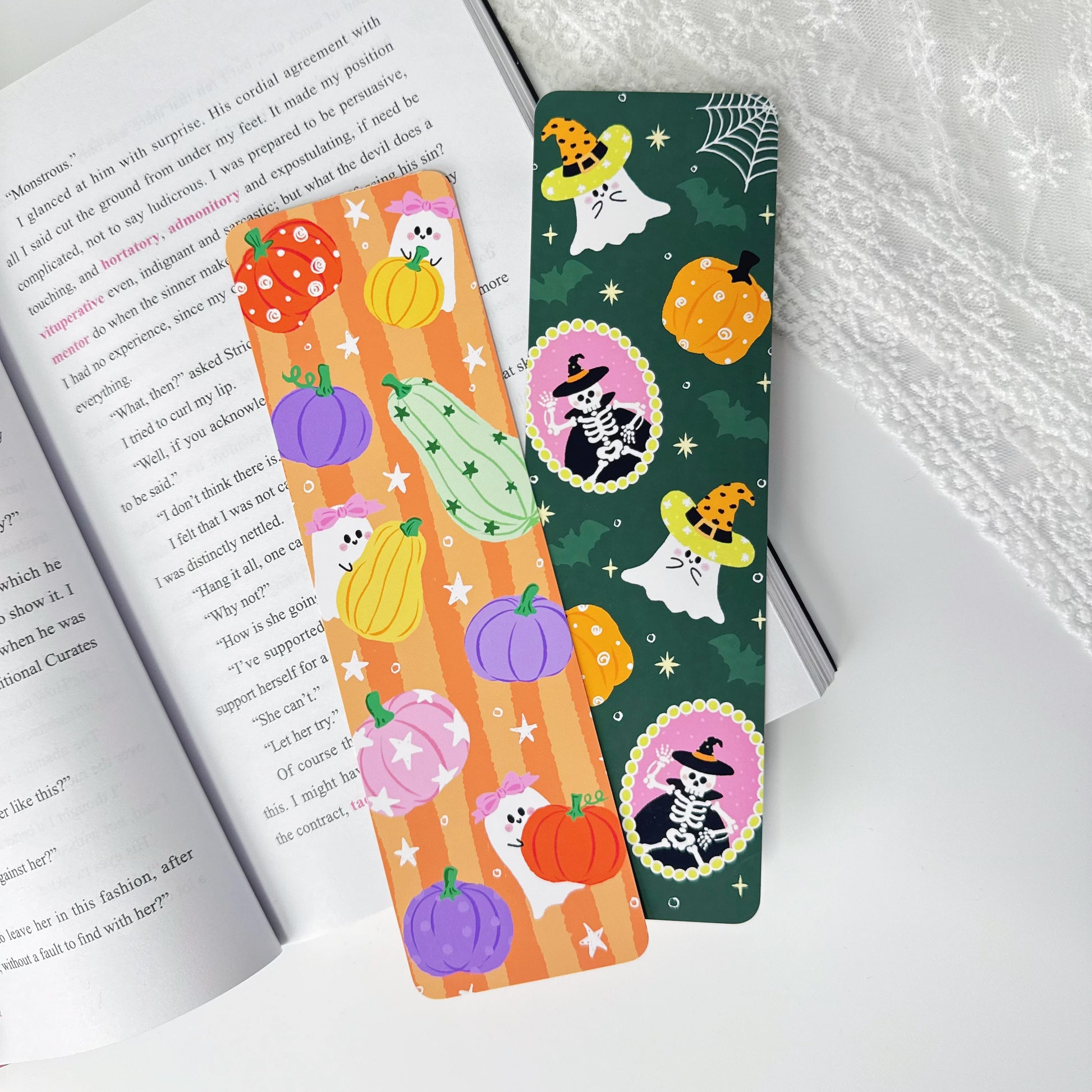 Two Halloween classic bookmarks displayed together on an open book