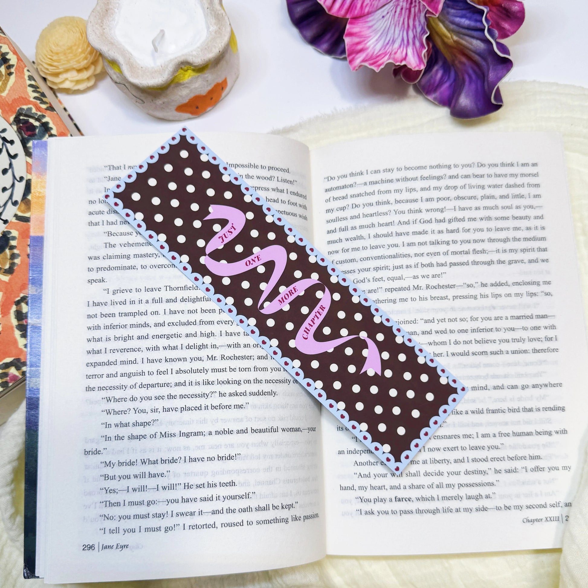 Just One More Chapter ribbon bookmark displayed on an open book page