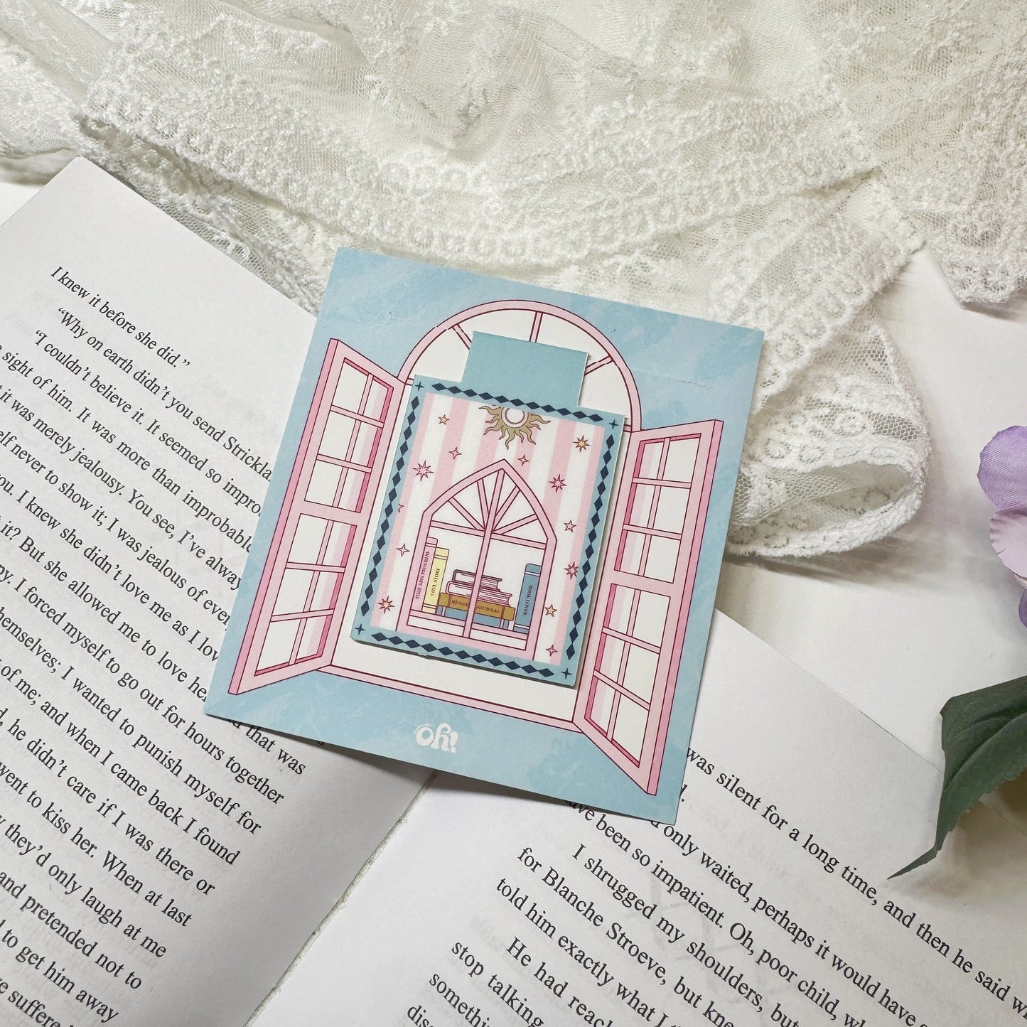 Pink book stack magnetic bookmark clipped on a book page