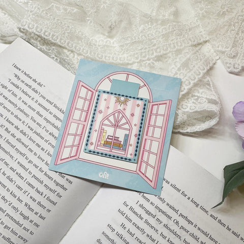Pink book stack magnetic bookmark clipped on a book page